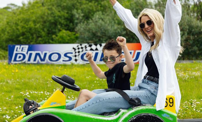 A mother and son cheering in the racing car.